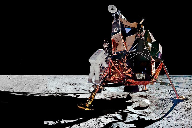 Astronaut steigt aus einem Mondlandemodul auf die Oberfläche des Mondes herab, umgeben von der schwarzen Leere des Weltraums.
