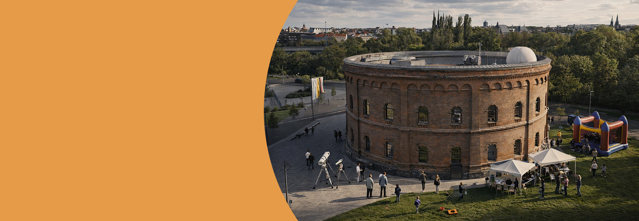 Das Headerbild zeigt das Planetarium Halle aus der Vogelperspektive. Es sind Teleskope und eine Hüpfburg sowie zahlreiche Menschen zu sehen. 