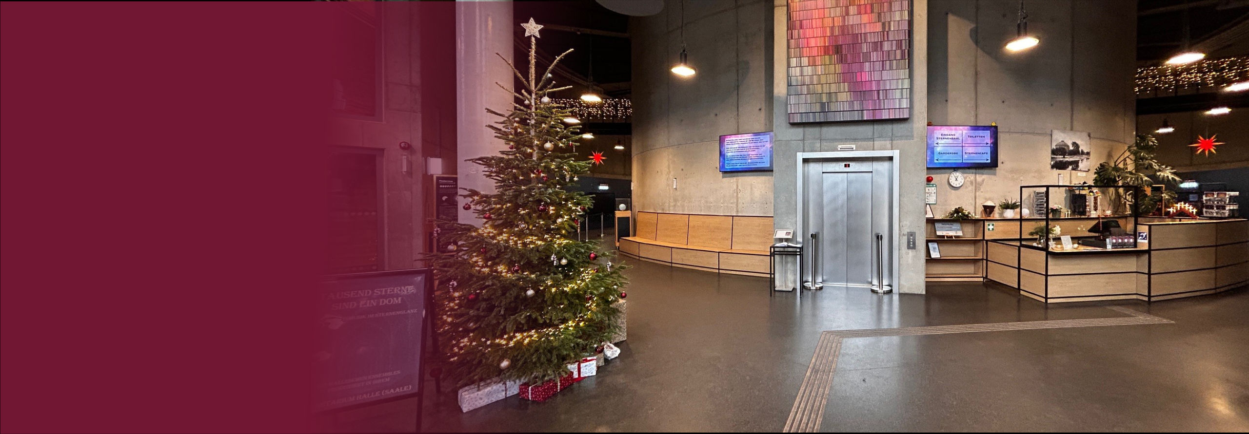 Der Eingangsbereich des Planetariums ist weihnachtlich geschmückt und es wird Frohe Weihnachten gewünscht.