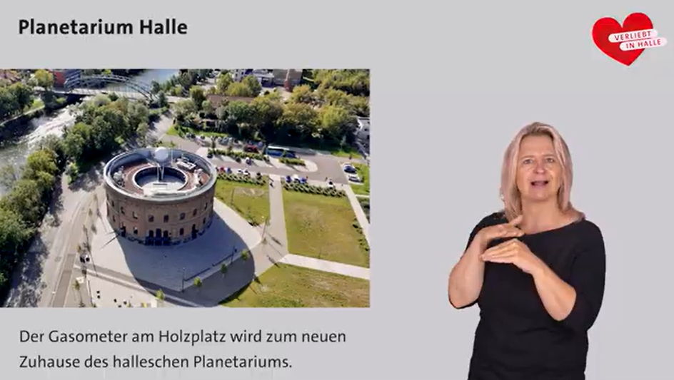 Es wird das Planetarium Halle aus der Vogelperspektive gezeigt, daneben ist eine Gebärden-Dolmetscherin zu sehen, die das Planetarium Halle vorstellt.