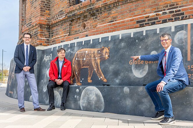 Egbert Geier, Matthias Lux und Dirk Schlesier vor dem als Jahresband der Sternbilder gestalteten Planetariums-Sockel.